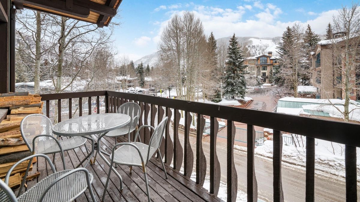 A private balcony at Chalet Schuss in Vail Valley overlooks snow-covered trees and ski slopes. With space for eight guests, this condo blends alpine charm with easy access to Vail’s vibrant ski village.