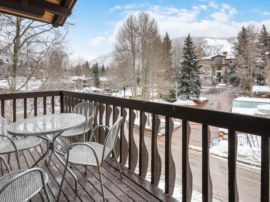 A private balcony at Chalet Schuss in Vail Valley overlooks snow-covered trees and ski slopes. With space for eight guests, this condo blends alpine charm with easy access to Vail’s vibrant ski village.