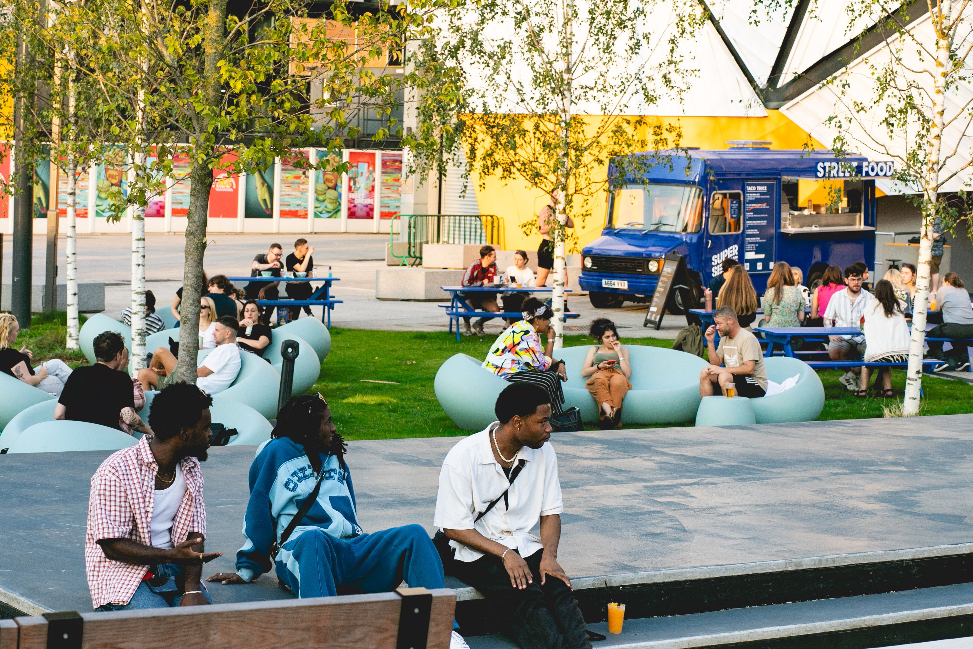 Groups of people sat in the sun outside Aviva Studios in St. John's