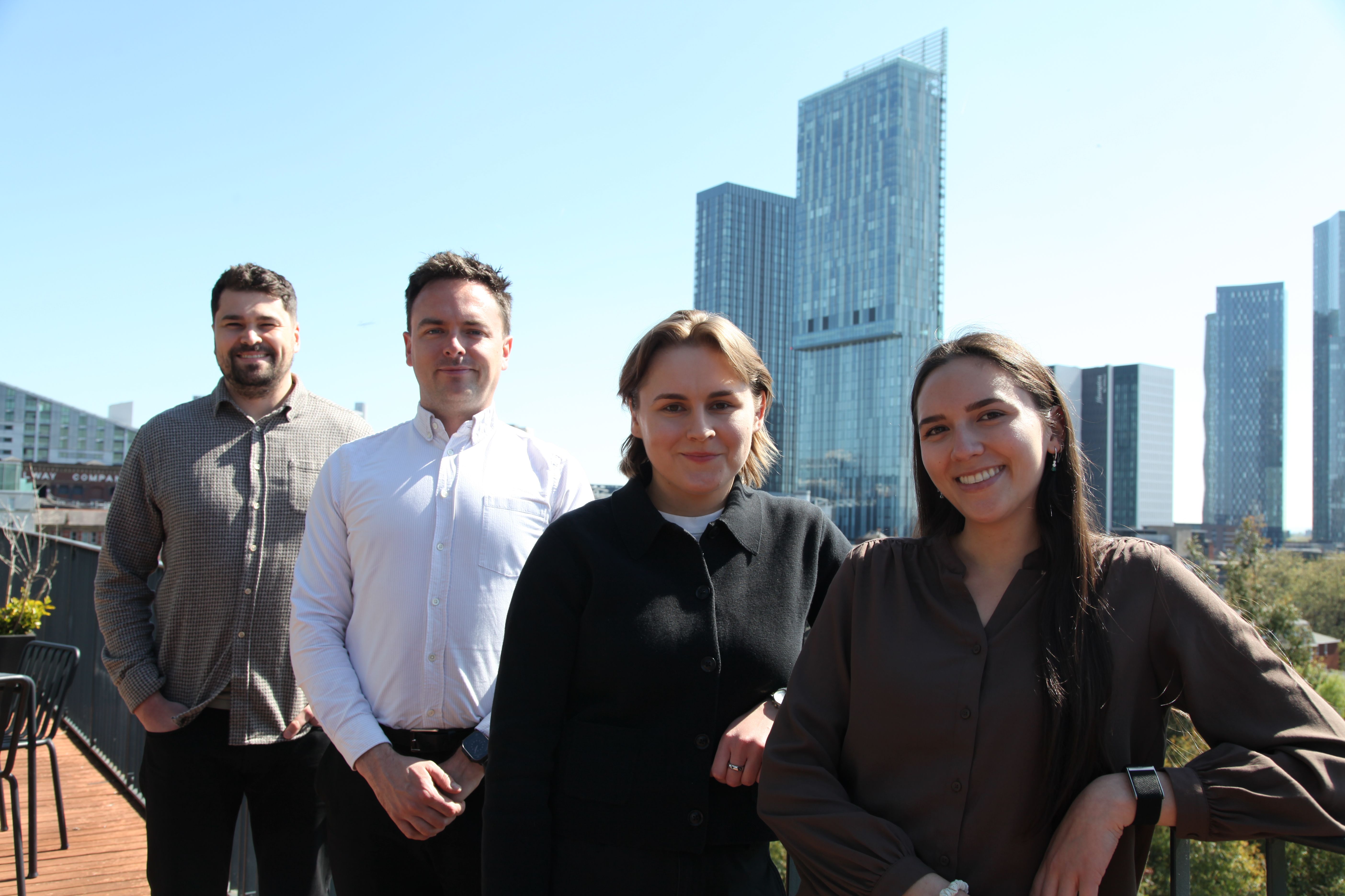 Joe, Jack, Charlotte and Lina on a rooftop in Manchester overlooking the Skyline