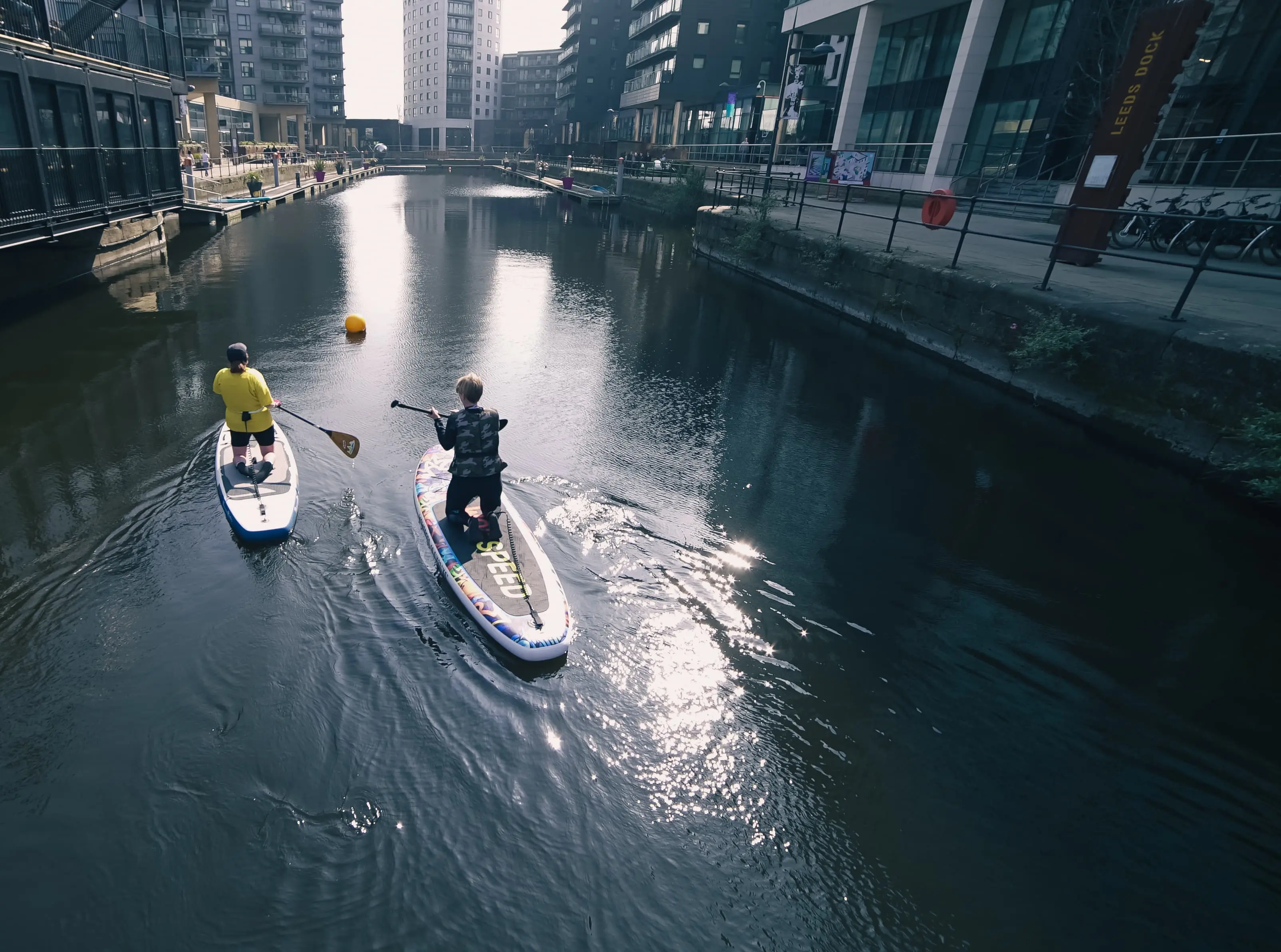 People paddleboarding in canal