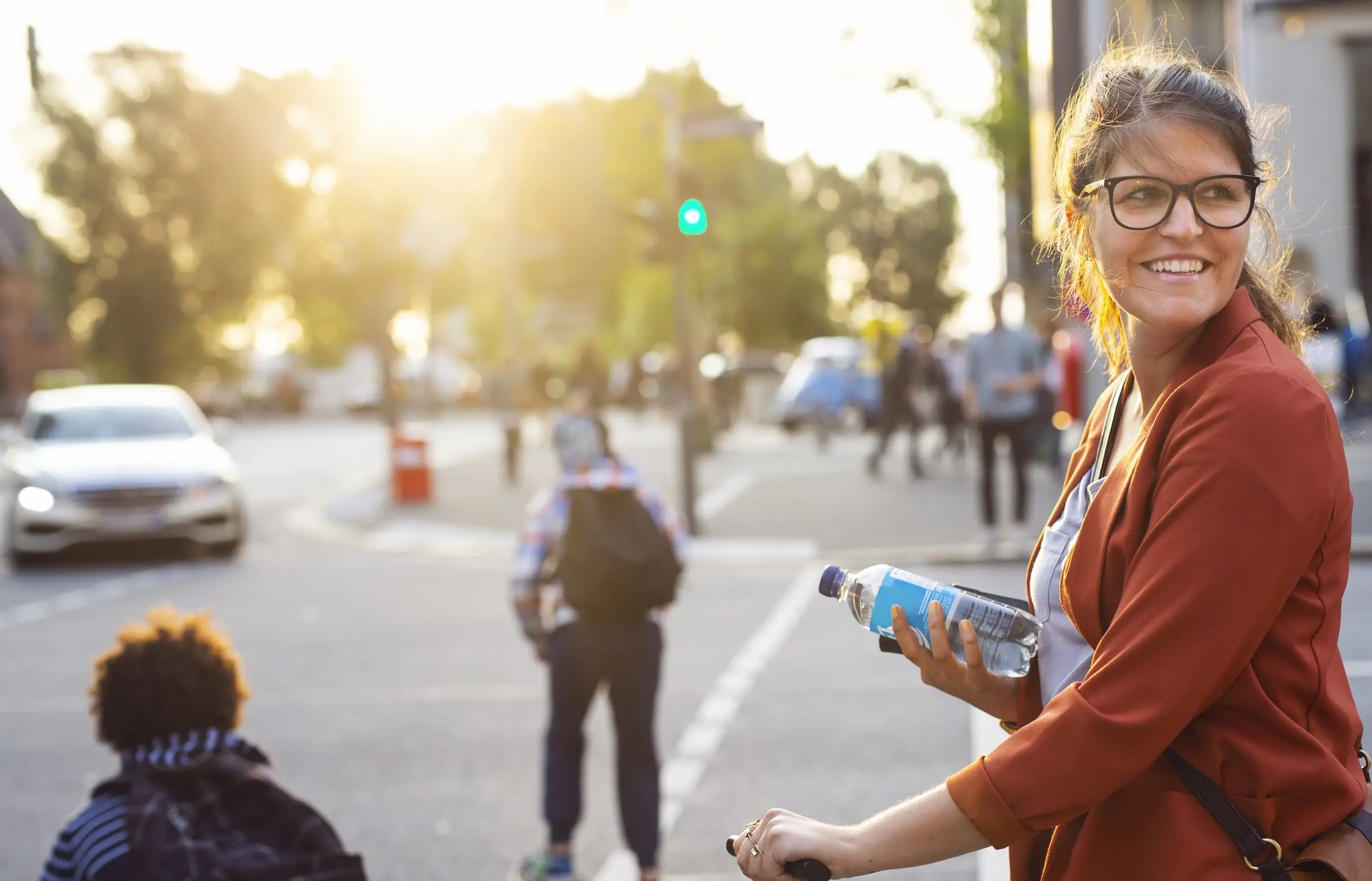 Woman holding a water bottle at a city crossing