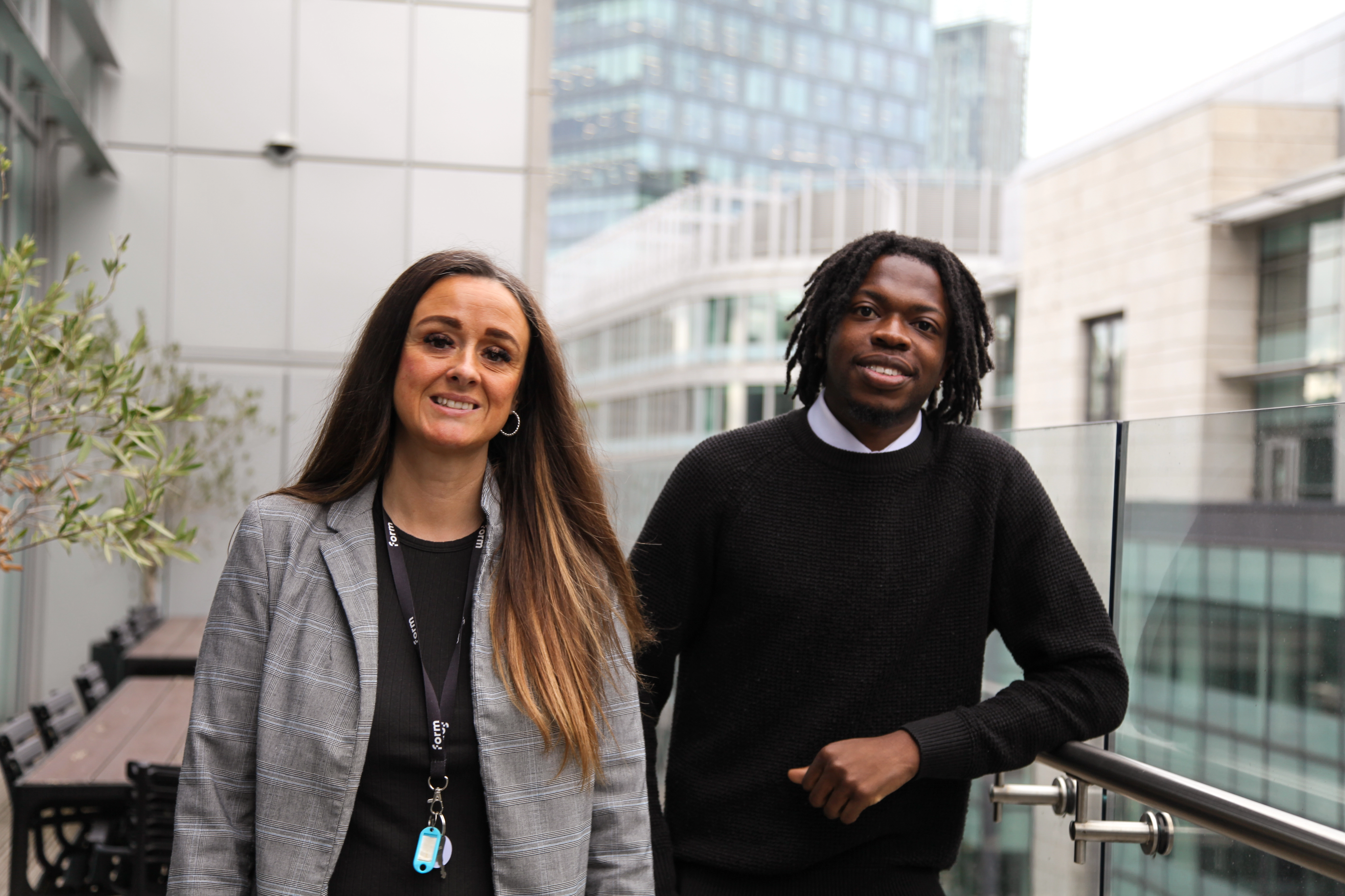 Andrea and Ademola stood smiling in XYZ Building, Spinningfields
