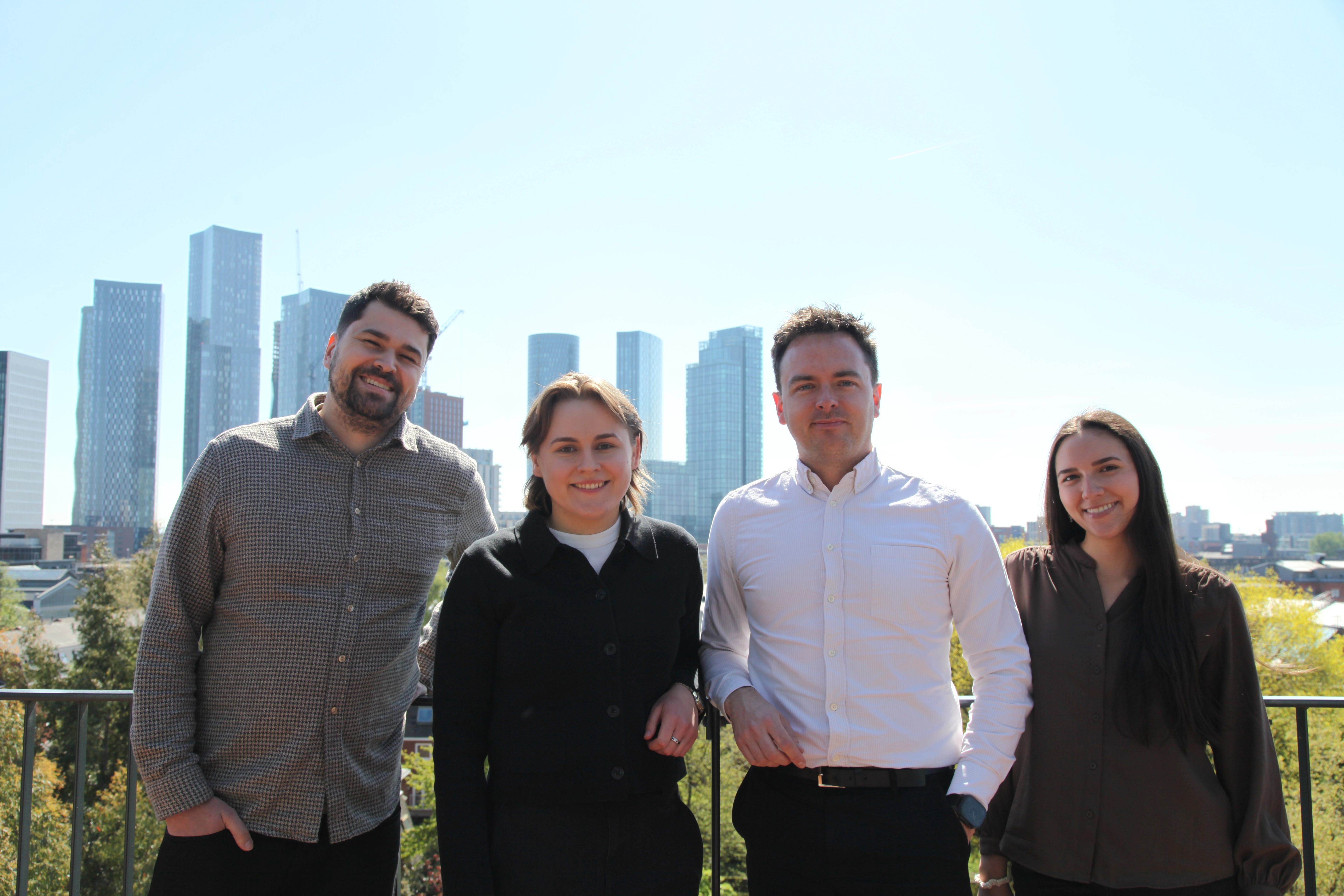 Joe, Charlotte, Jack and Lina stood on a rooftop overlooking the Manchester Skyline