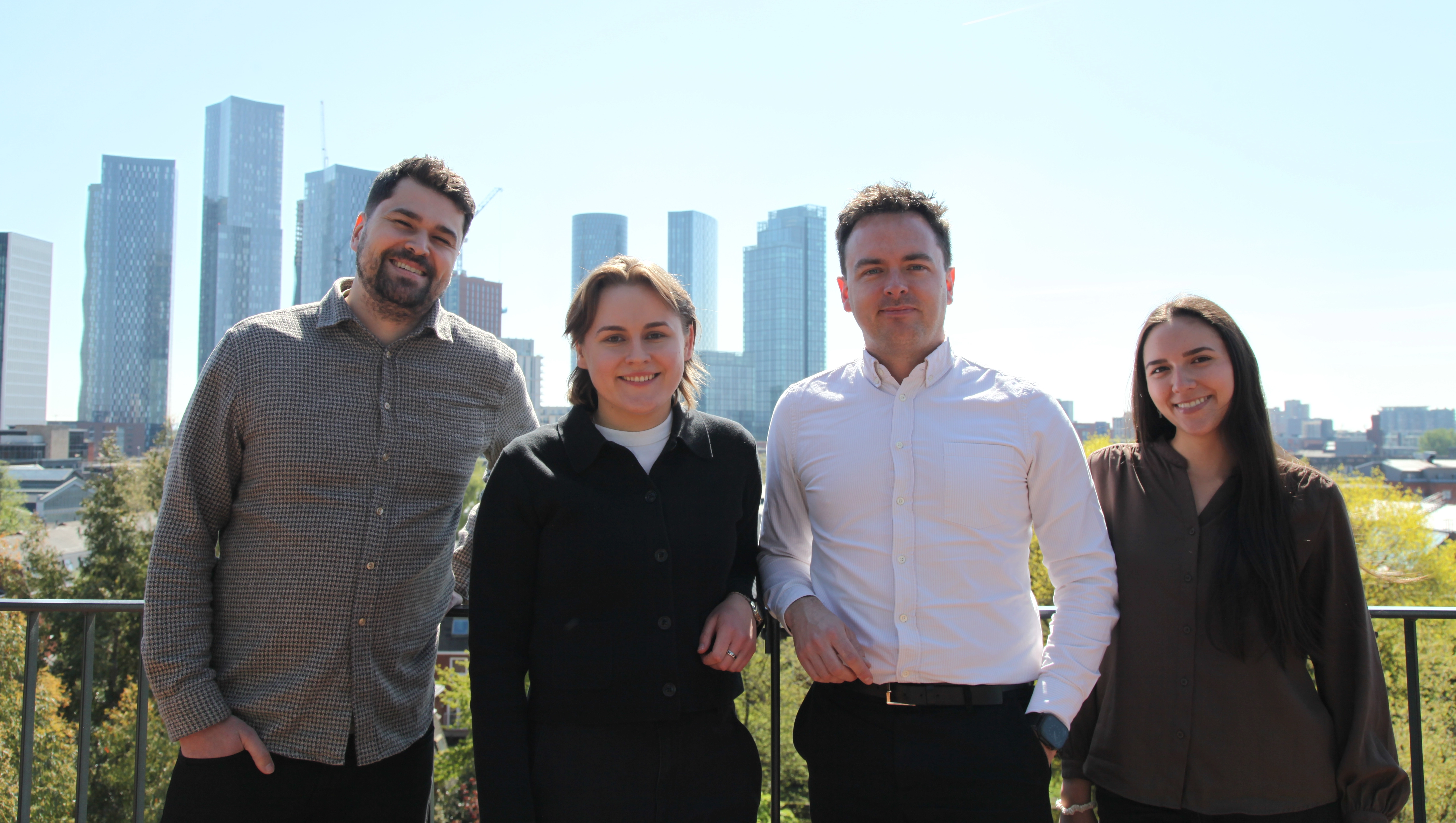 Joe, Charlotte, Jack and Lina stood on a rooftop overlooking the Manchester Skyline