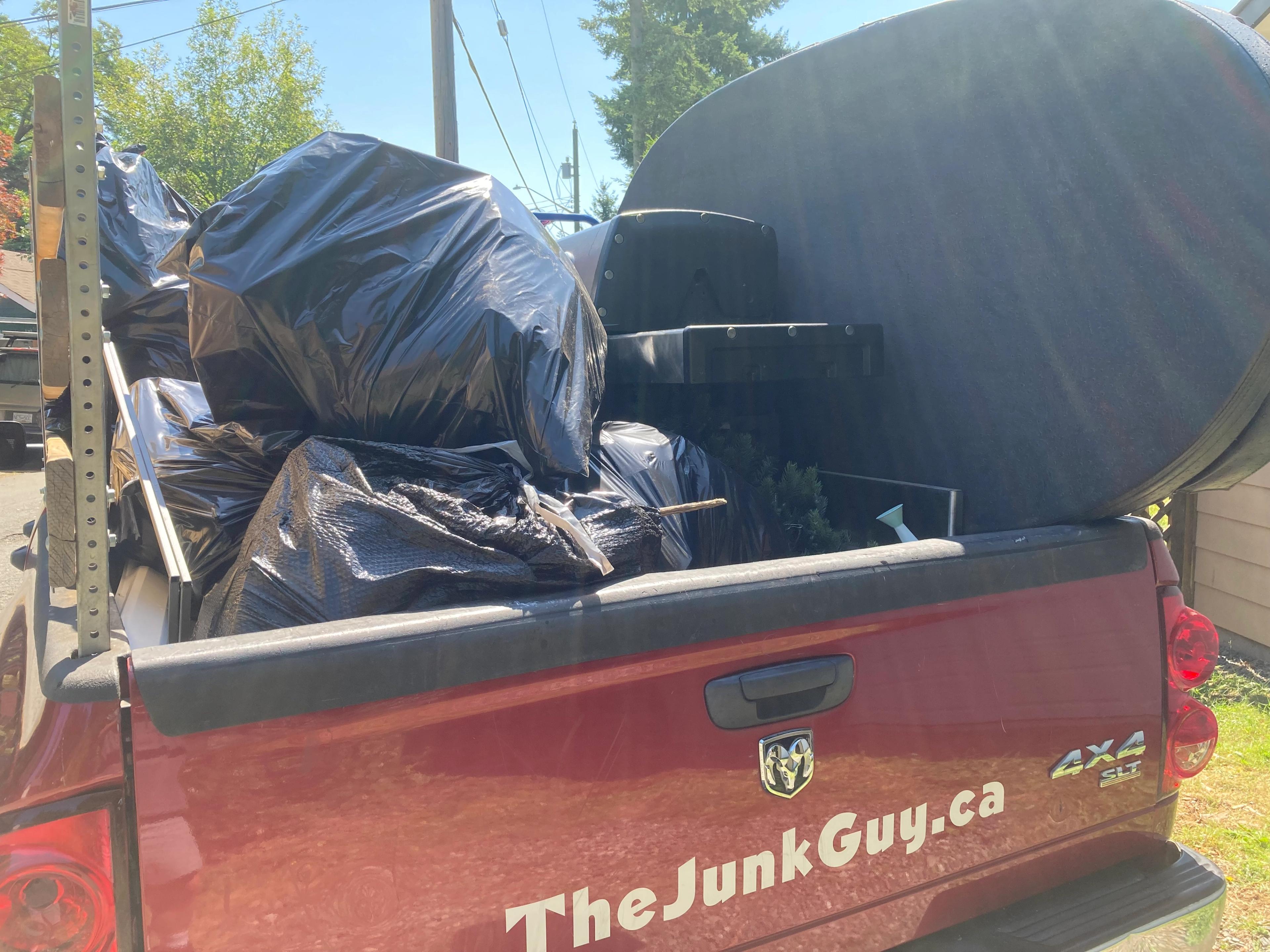 Hot tub cover, old BBQ and bags of garbage from a shed cleanout
