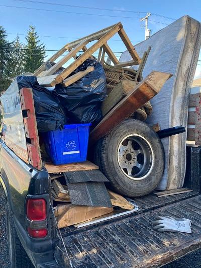 Old mattress, tire, patio chairs and planters in a mixed load