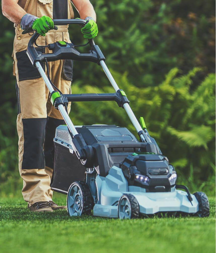 A man mowing the lawn with a lawnmower