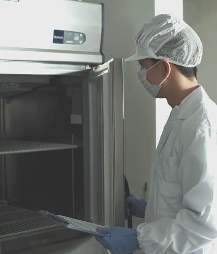 A person wearing a face mask inspecting a furnace