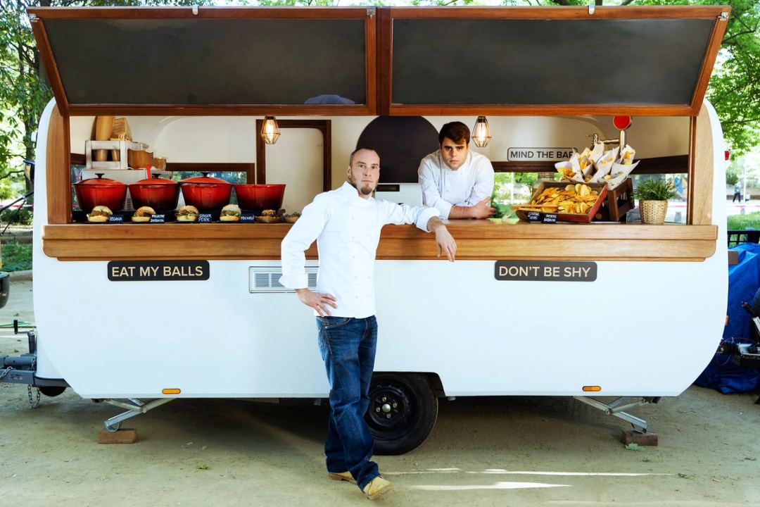 Handsome young chef looking at camera in a food truck.