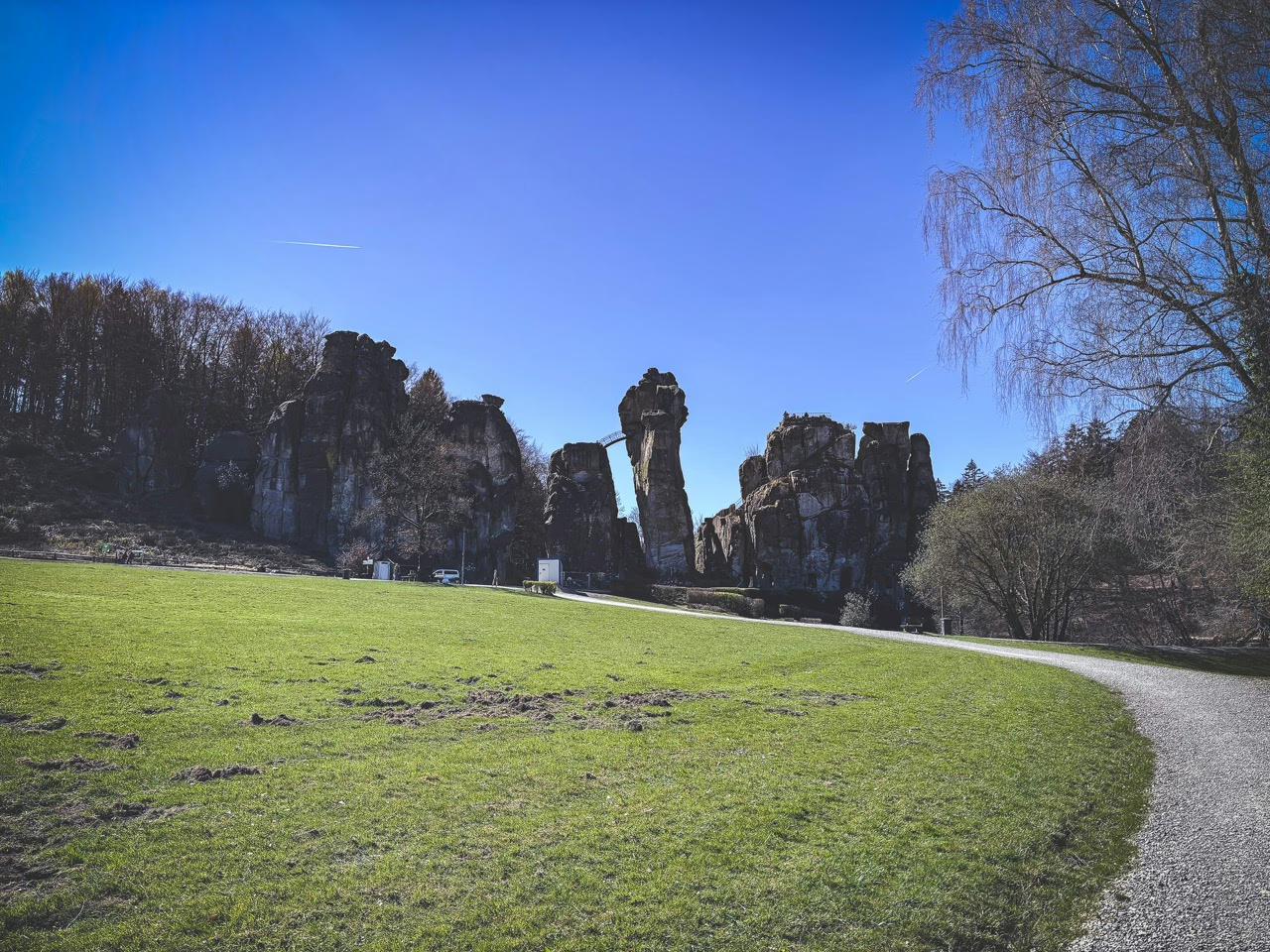 Die Externsteine von der großen Wiese aus gesehen, mit Spazierweg am Rand