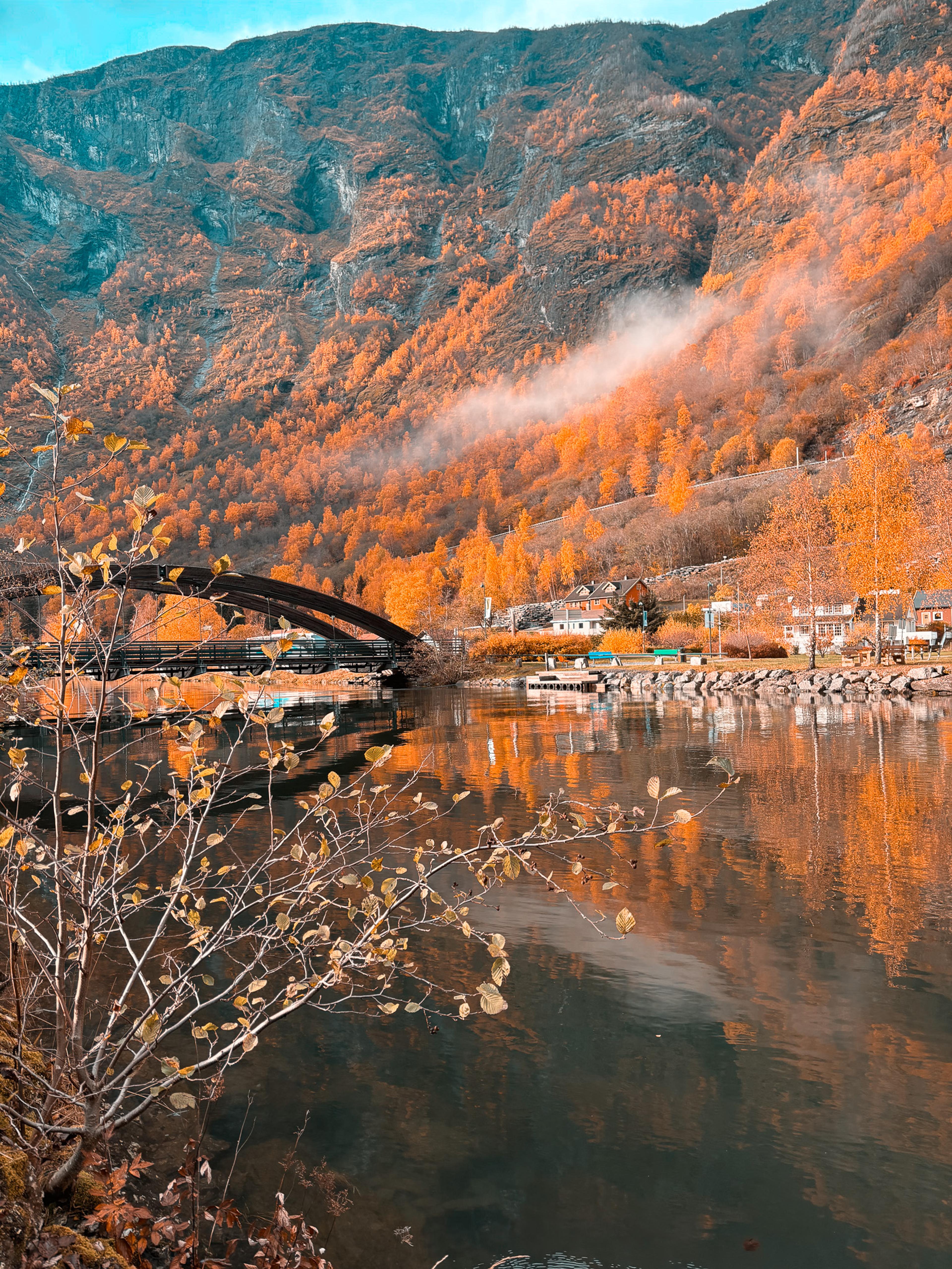Herbstliche Fjordlandschaft bei Flåm mit Brücke und Spiegelung im Wasser