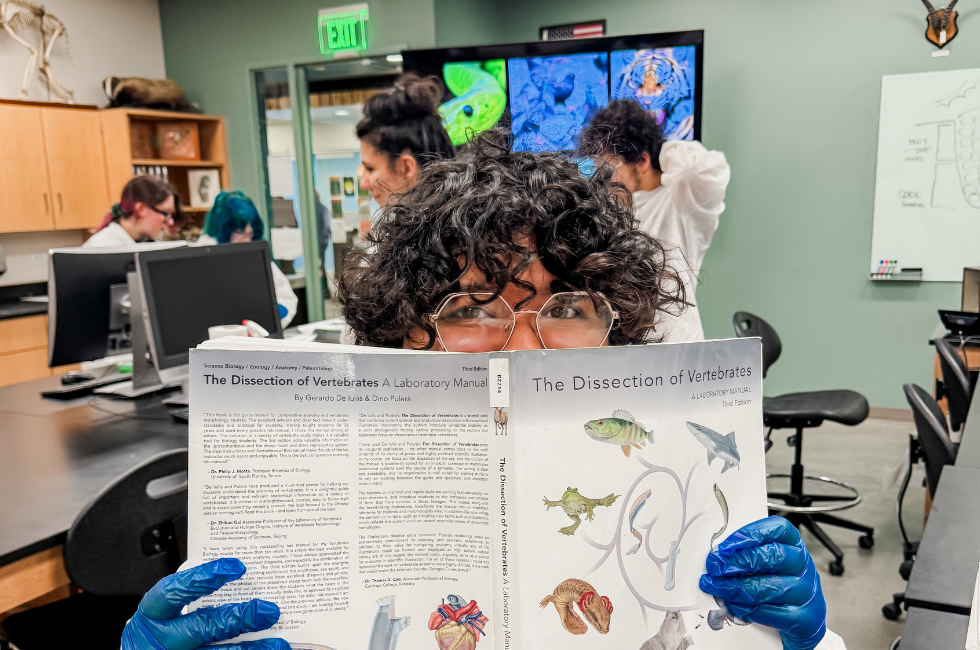 Student holds dissection textbook