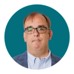A headshot of Will Kelly against a teal background