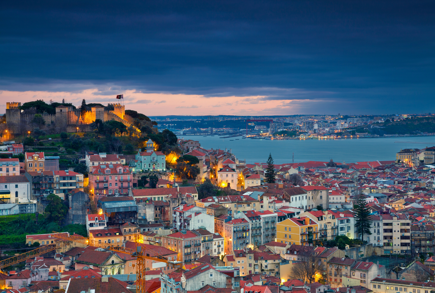 A drone shot of Lisbon, Portugal showing its buildings and coastline