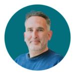 A headshot of Adam Wignall against a teal background