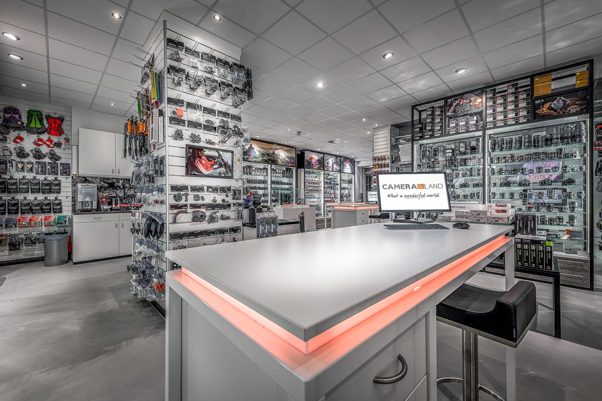 Modern winkelinterieur van Cameraland in Alkmaar, met overzichtelijke presentatie van camera’s, objectieven en accessoires, verlichte vitrines en een centrale advies- en demonstratiebalie.