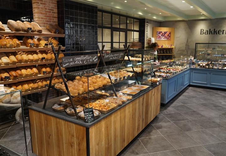 Modern bakkerij-interieur ontworpen en gebouwd door Infrashop, met maatwerk winkelinrichting, houten broodpresentatie, vers brood, gebaksvitrines en industriële details
