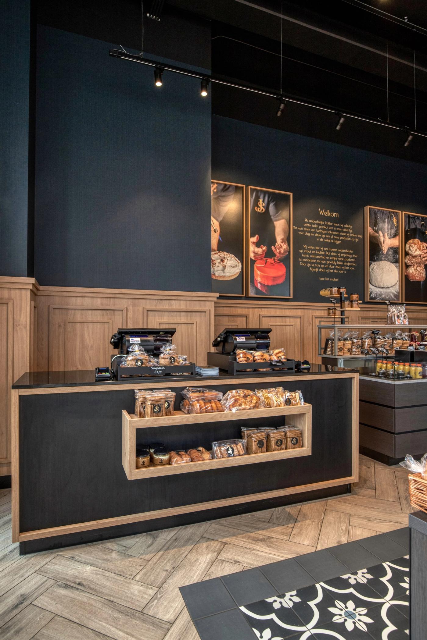 Toonbank met koffiemachine en houten lambrisering bij Warme Bakker Jac Smit.
