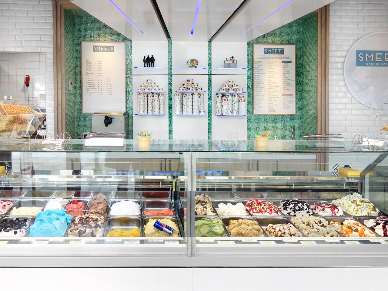 Modern ijssalon-interieur van Smeets, ontworpen en gebouwd door Infrashop, met maatwerk ijsvitrine, ambachtelijk schepijs, kleurrijke presentatie en groene mozaïektegels.