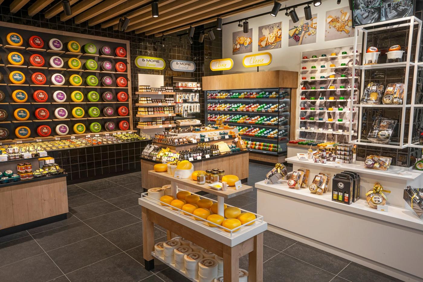 Overzicht van de winkel van Cheese & More in Leidschendam, met een kaaswand, presentatietafels en schappen met kaascadeaus.