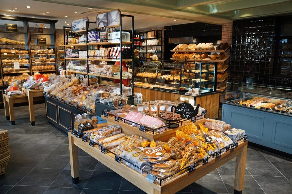 Complete winkelinrichting van ambachtelijke bakkerij ontworpen en gerealiseerd door Infrashop, met broodpresentatie, gebaksvitrines, maatwerk meubels en productpresentatie.