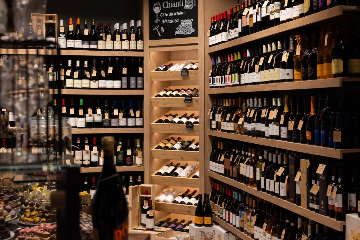 Wijnwand met houten schappen bij Gastrovino Leiden.