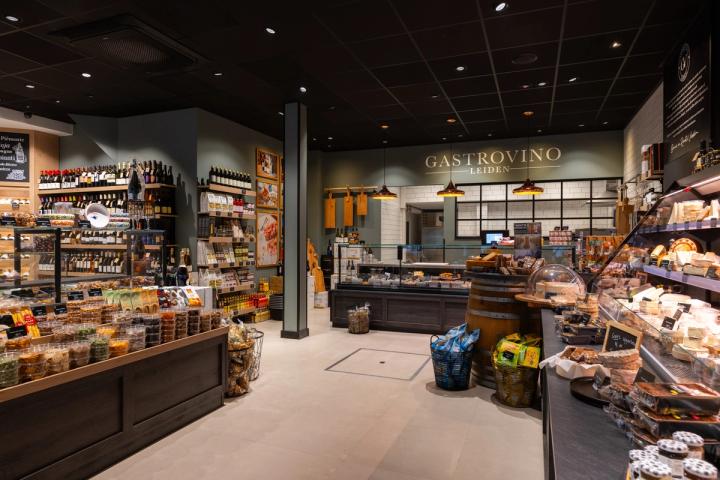 Overzicht van de winkel van Gastrovino in Leiden, met toonbanken en wandschappen met delicatessen.