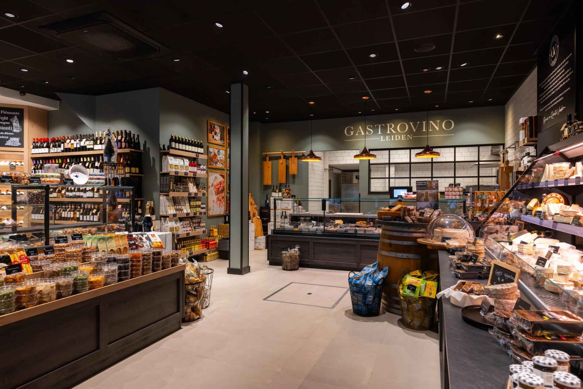 Overzicht van de winkel van Gastrovino in Leiden, met toonbanken en wandschappen met delicatessen.