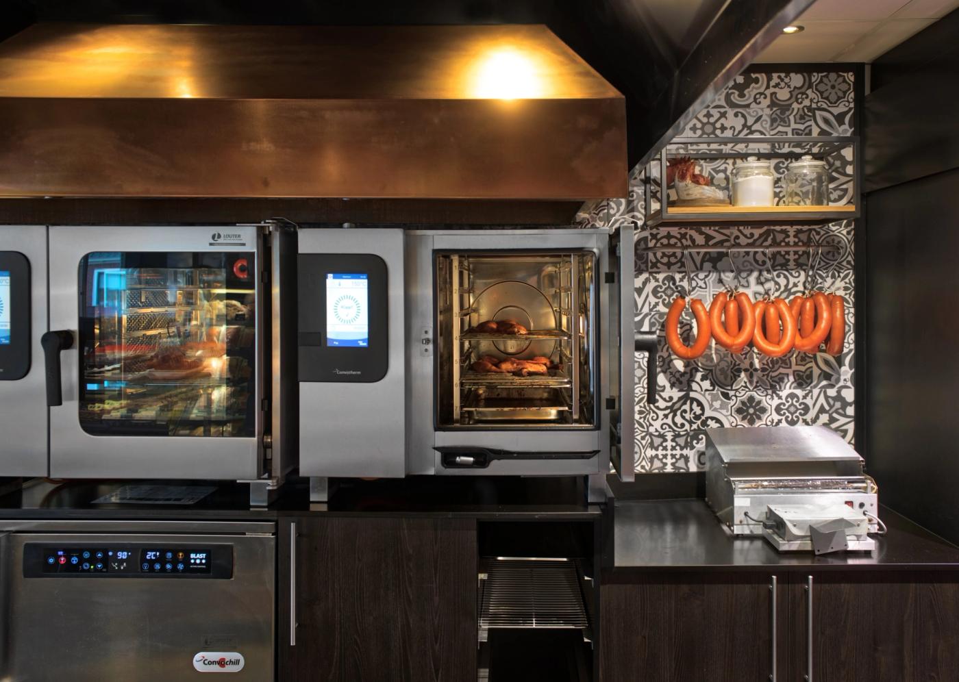 De twee ovens in de centrale keuken onder de koperen schouw.