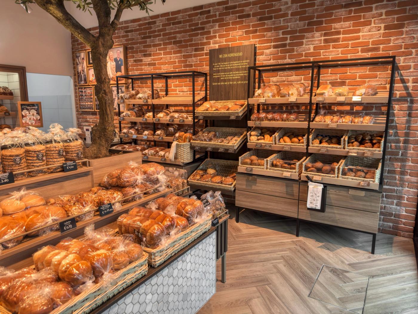Broodwand met houten schappen voor een bakstenen wand bij Korengoud in Rosmalen.