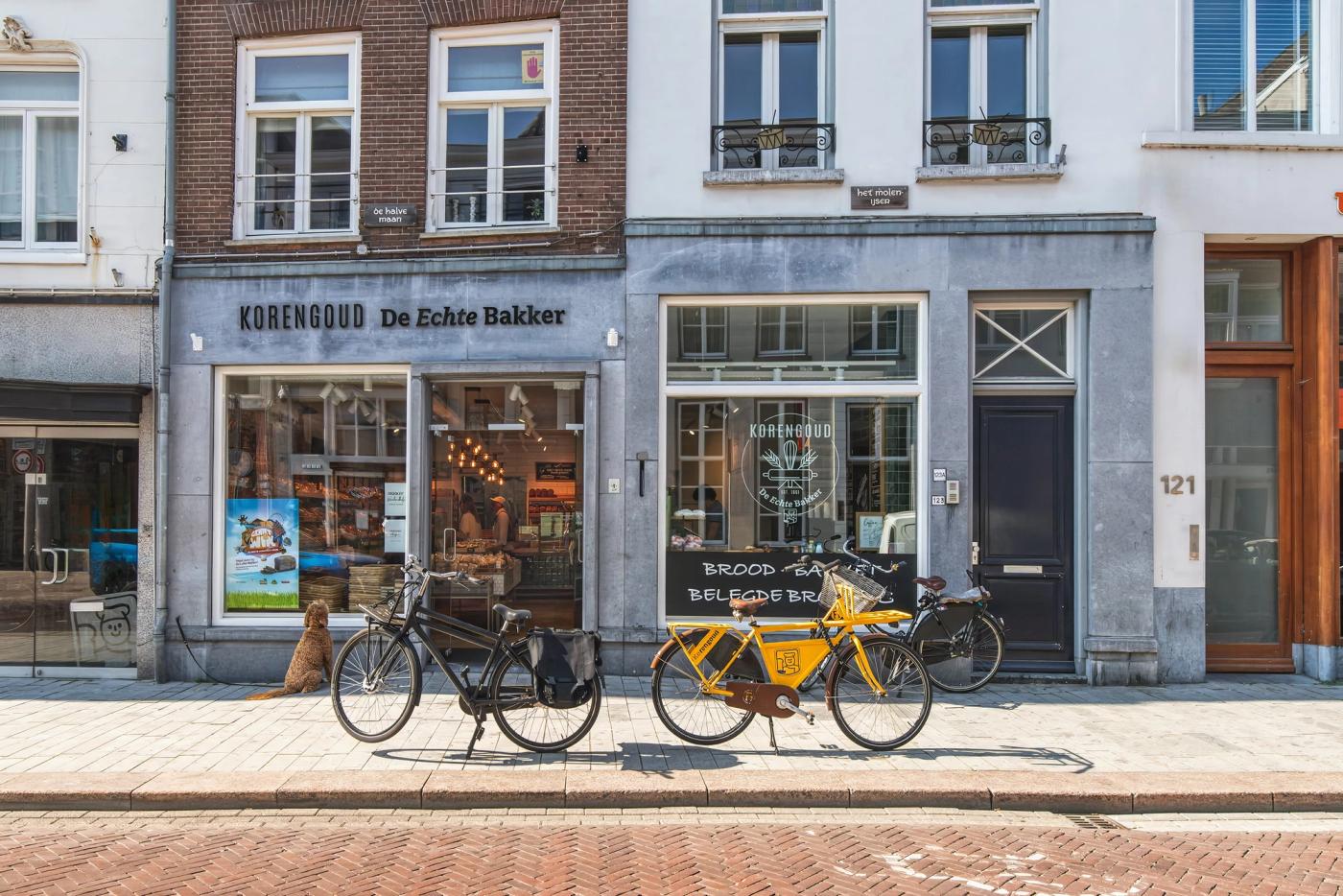 Gevel van Korengoud De Echte Bakker aan de Hinthamerstraat in Den Bosch, met fietsen voor de etalage.