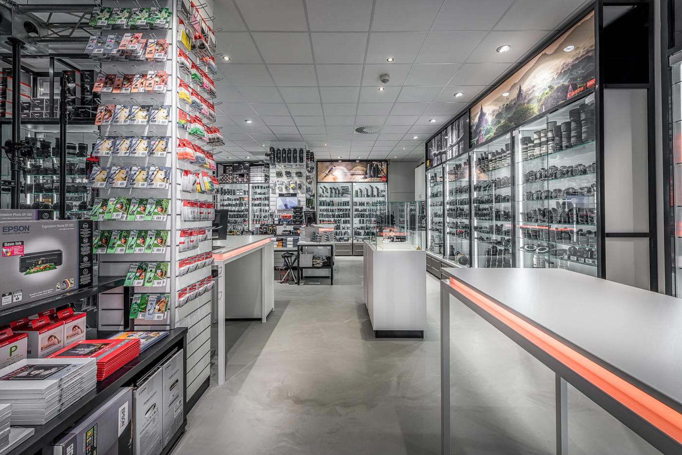 Modern winkelinterieur van Cameraland in Alkmaar, met verlichte vitrines voor camera’s en objectieven, uitgebreide accessoirepresentaties en een centrale adviesbalie.