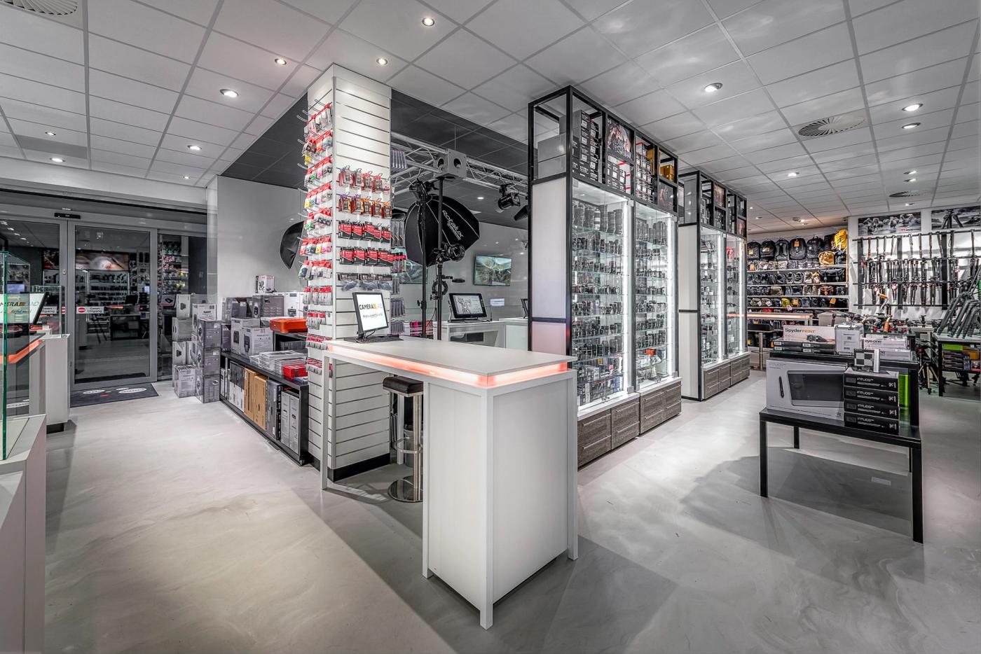 Modern winkelinterieur van Cameraland in Alkmaar, met verlichte vitrines voor camera’s en objectieven, uitgebreide accessoirepresentaties en een centrale adviesbalie.