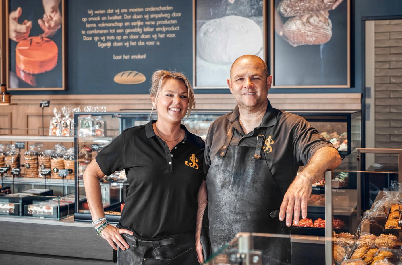 Twee medewerkers van Warme Bakker Jac Smit voor de toonbank.