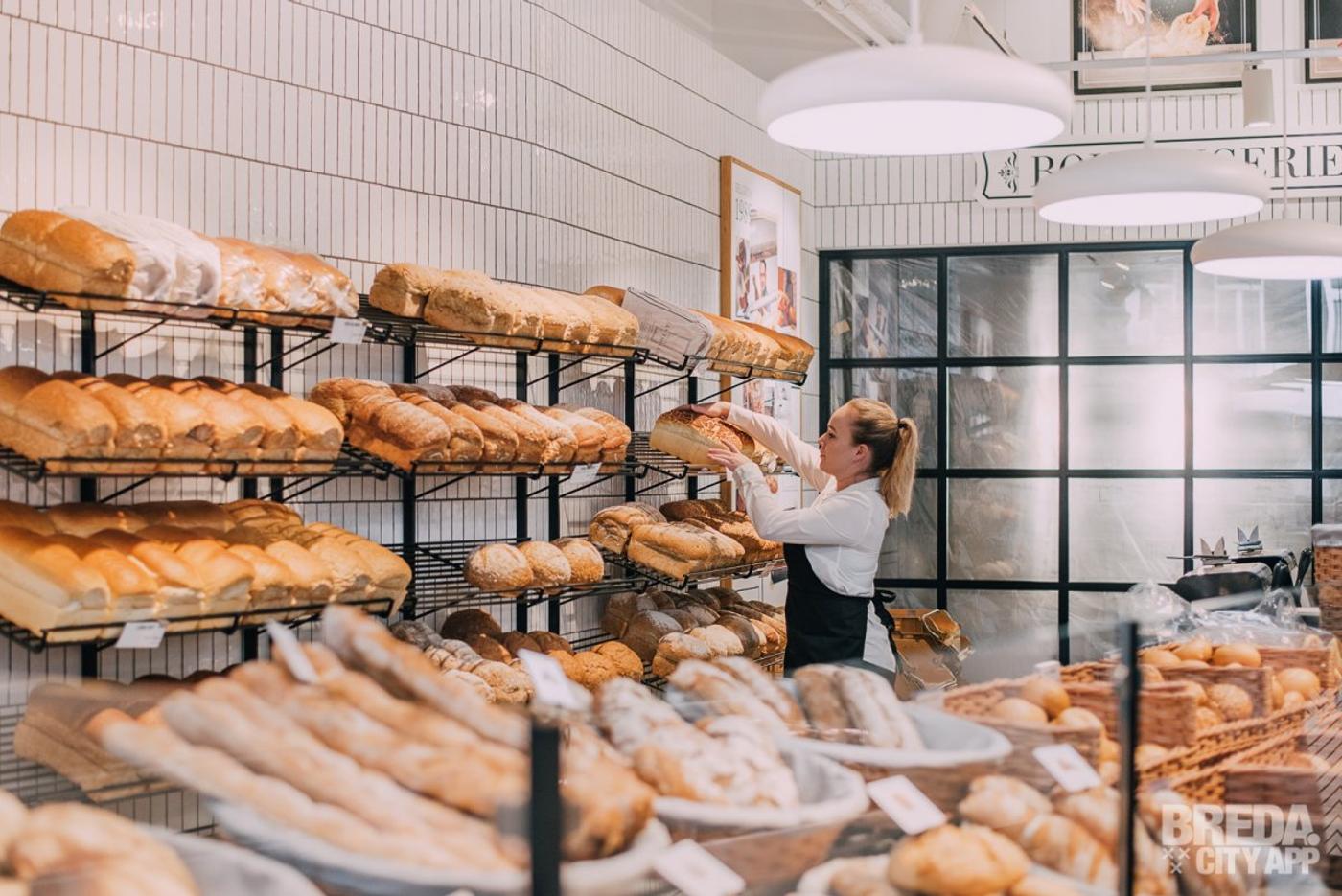 Modenren broodpresentatie in zwart gecoate stalen broodrekken op een wit betegelde wand