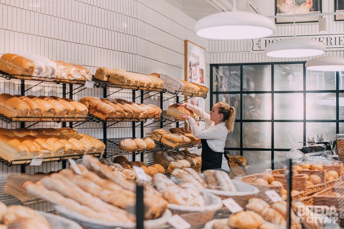Modenren broodpresentatie in zwart gecoate stalen broodrekken op een wit betegelde wand