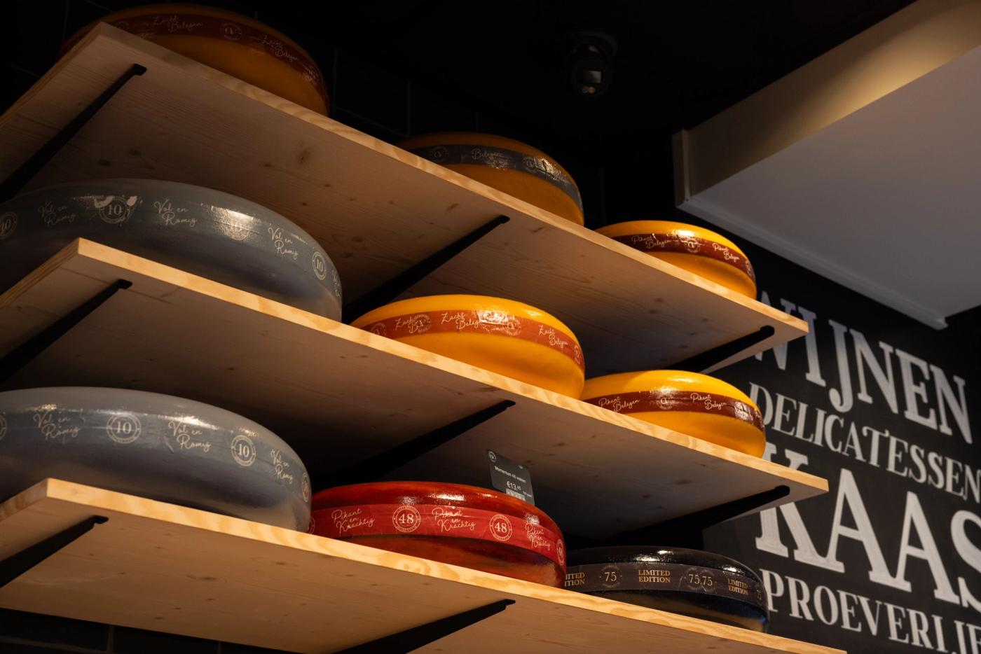 Kaaswielen op houten schappen bij Gastrovino Leiden.