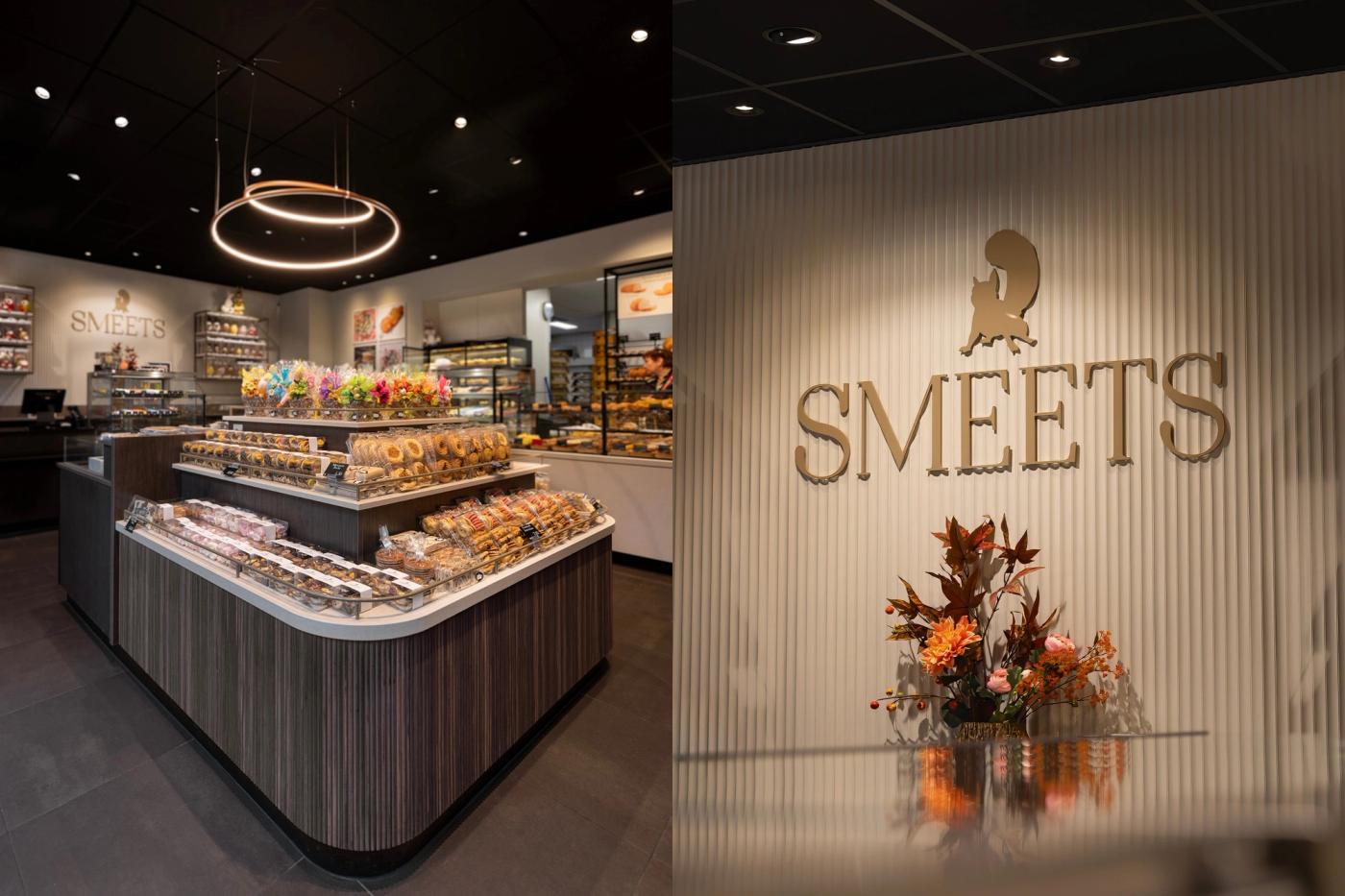 Middeneiland met gebak en koek bij Banketbakkerij Smeets, naast de lichte wand met het Smeets-logo.