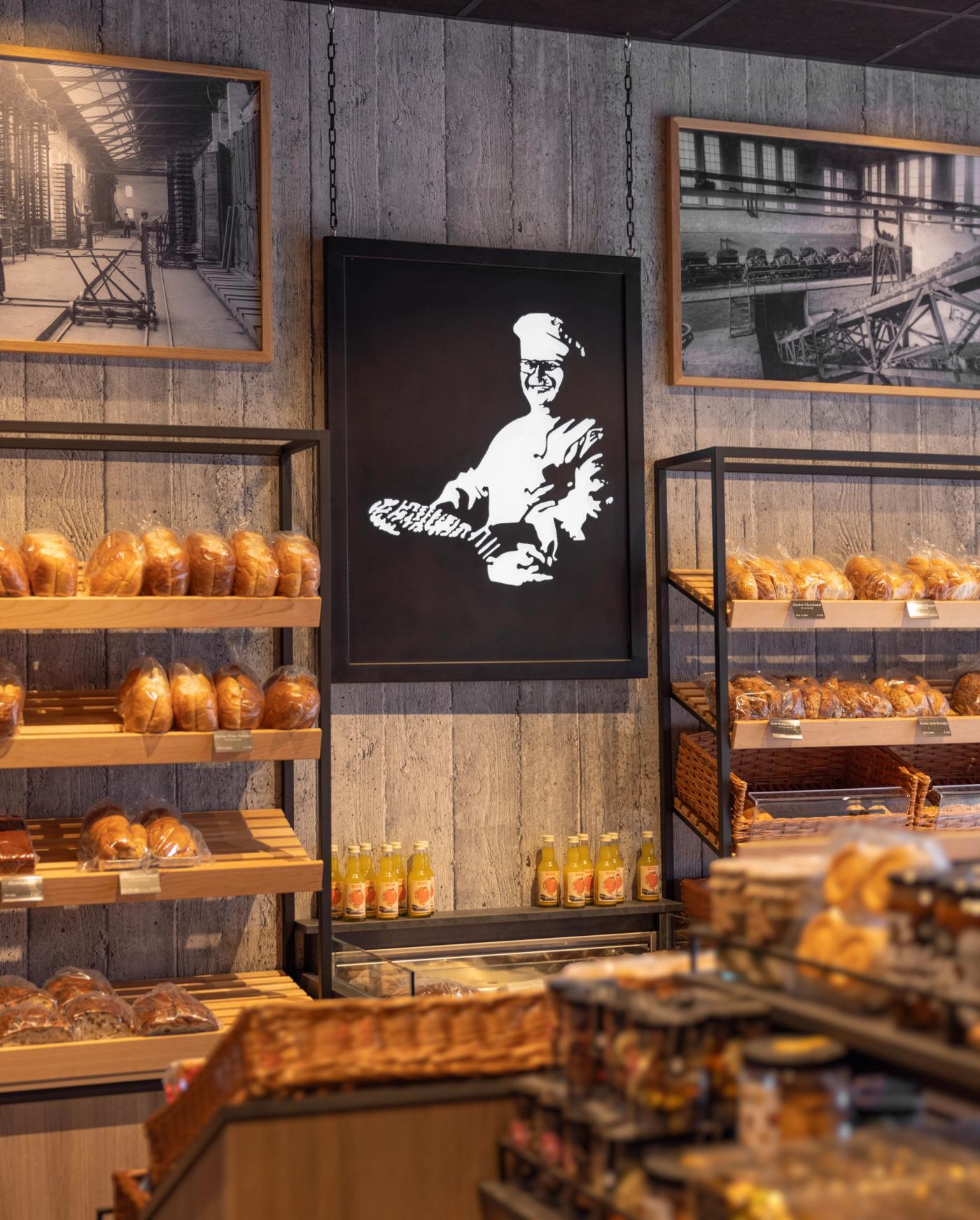 Stalen lichtbak van Joep Kuppers als karakteristiek designelement in de winkel van Bakkerij Jos Puts in Echt, gecombineerd met historische fotografie en ambachtelijke broodpresentatie.