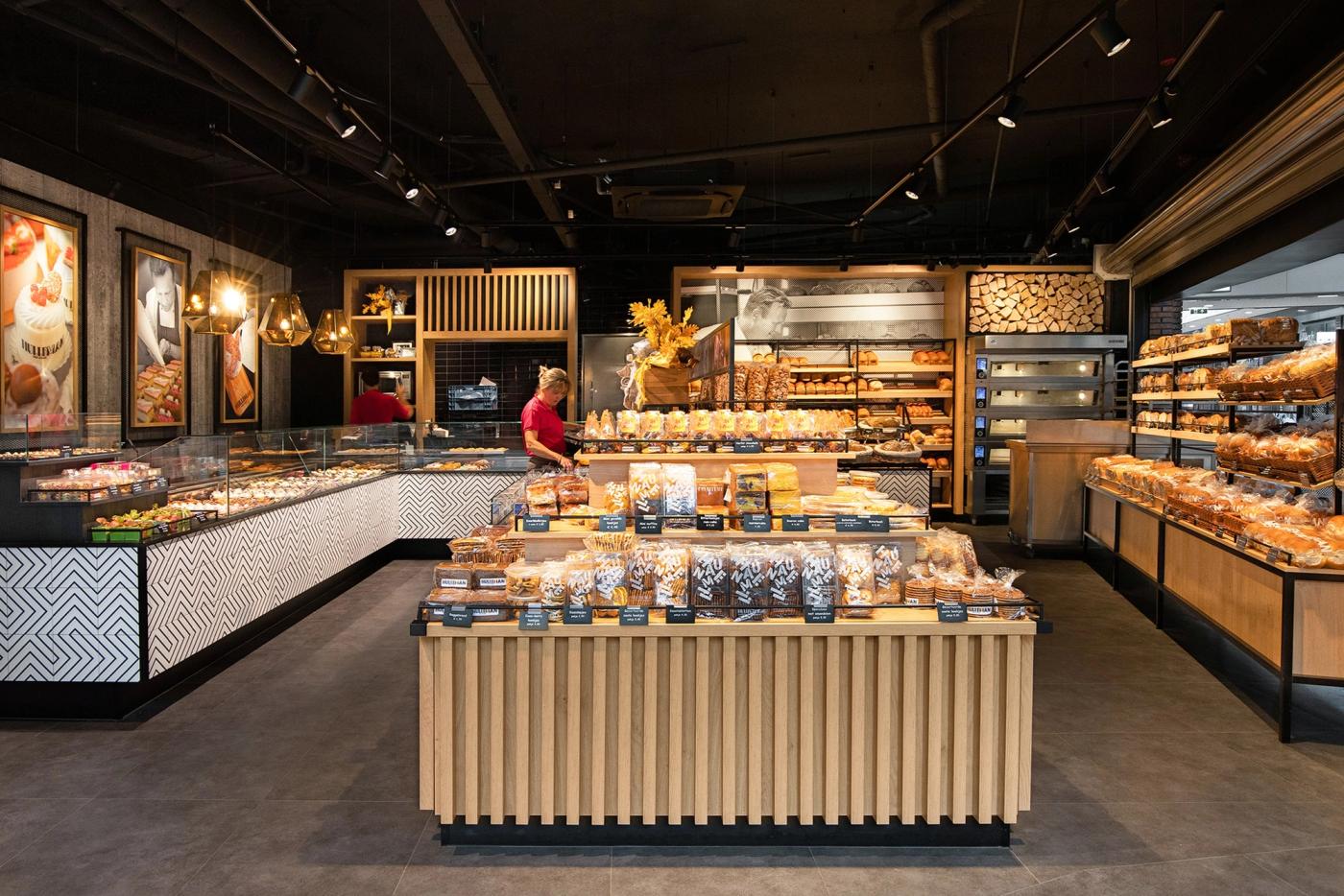 Overzicht van de winkel van Bakker Hulleman, met een houten middenmeubel en sfeerverlichting.