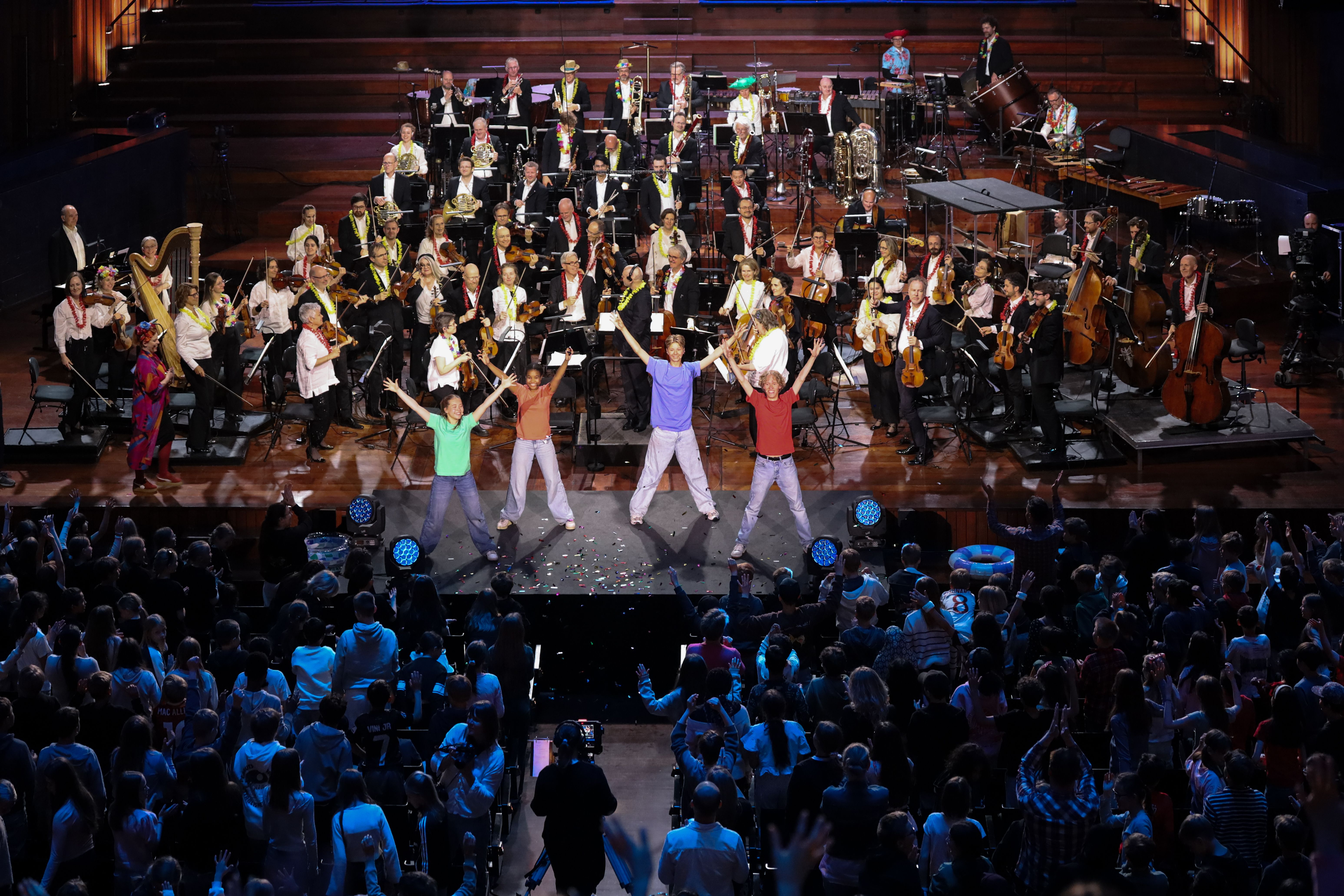 Orkester, forsangere og skolebarn i salen