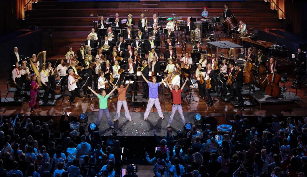Orkester, forsangere og skolebarn i salen