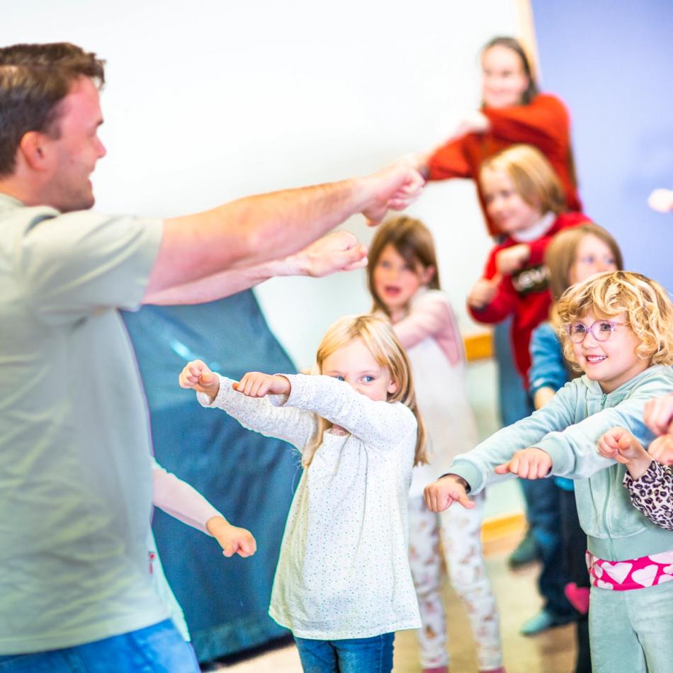 Lærer leder sanglek med elever på Haslum skole