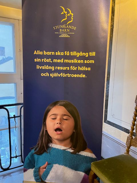 Rollup med bilde av barn som synger. Påskrift på svensk: Alla barn ska få tillgång til sin röst.