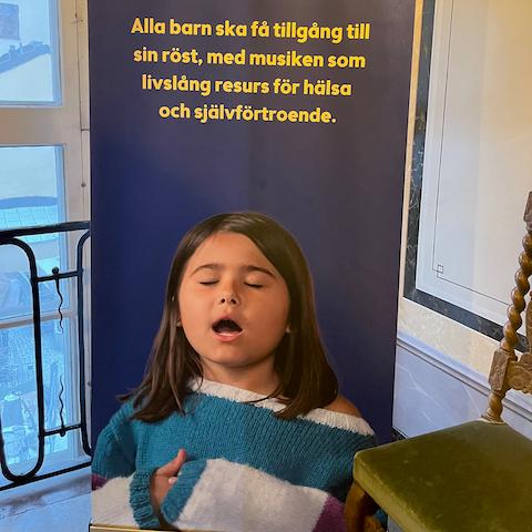 Rollup med bilde av barn som synger. Påskrift på svensk: Alla barn ska få tillgång til sin röst.