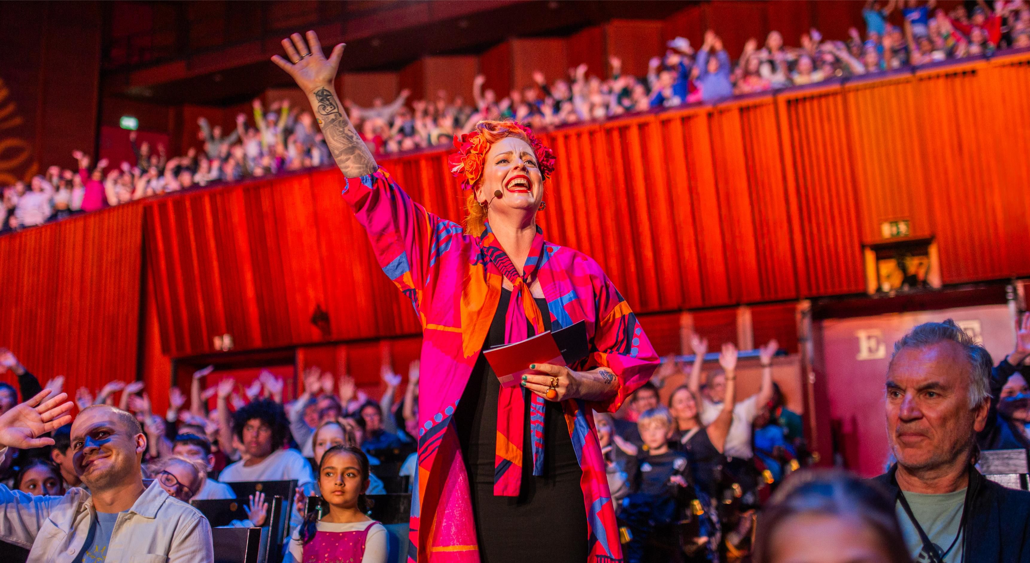 Programleder Silya hilser elever fra hele landet som ser på opptakene fra Skolenes sangdag 2025 i Oslo konserthus. I salen synger over 1000 elever sammen med Oslo-filharmonien.