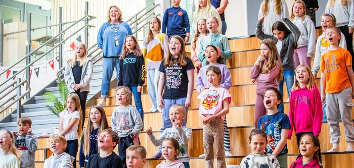 Elever synger i auditoriet på skolen sin