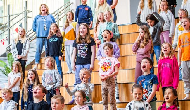 Elever synger i auditoriet på skolen sin