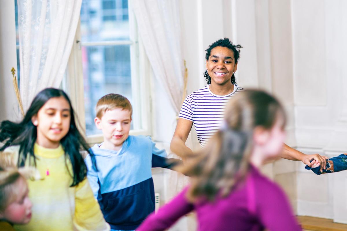 Elever synger sammen i ringdans.